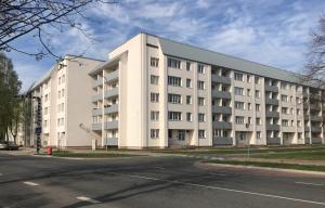een groot wit gebouw op de hoek van een straat bij Apartment128 in Valmiera