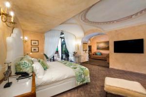 - une chambre avec un grand lit et une télévision dans l'établissement Palazzo Marziale, à Sorrente