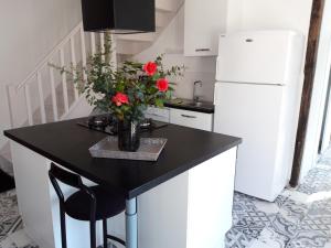 a kitchen with a table with a vase of flowers on it at Le Petit Lustucru in Saint-Martin-des-Champs