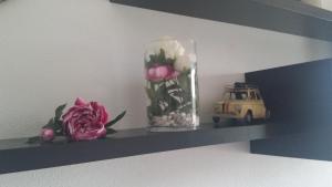 un estante con un jarrón de flores y un coche de juguete en APARTAMENTO EN CAMPO DE GOLF, en Cirueña