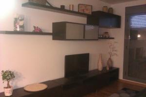 uma sala de estar com uma televisão de ecrã plano na parede em APARTAMENTO EN CAMPO DE GOLF em Cirueña