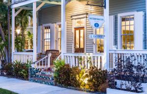 una casa bianca con un portico e un cartello sopra di Southernmost Inn Adult Exclusive a Key West