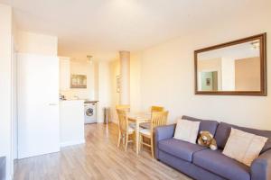 a living room with a blue couch and a table at Stylish Merchant City Flat in Glasgow