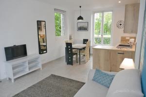 ein Wohnzimmer mit einem Sofa und eine Küche mit einem Tisch in der Unterkunft VILLA CAMILLE - Proche Paris & Disneyland in Lagny