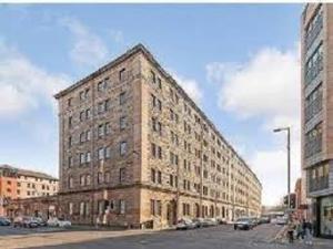 a large brick building on the side of a street at Stylish Merchant City Flat in Glasgow