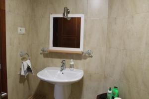 un baño con lavabo y espejo en Apartamento San Roque, en Finisterre 26 fotos más