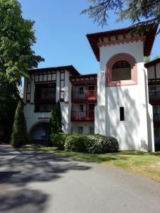 a large white building with a red balcony at Appartement Le parc d Arradoy in Saint-Jean-Pied-de-Port