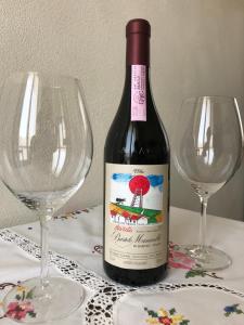 a bottle of wine sitting next to two wine glasses at La Mascarella in Alba