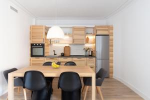 a kitchen and dining room with a wooden table and chairs at Casa Cosi - Eixample 5 in Barcelona
