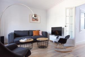 a living room with a blue couch and chairs at Casa Cosi - Eixample 5 in Barcelona
