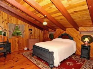 a bedroom with a bed and a wooden ceiling at Cedarwood Lodge in Penfield