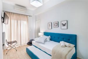 una camera con un letto blu e una sedia di Anaria Blue Suite a Ermoupoli
