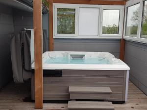 a jacuzzi tub in a bathroom with two windows at LA BINAMERIE in Remicourt +25 photos