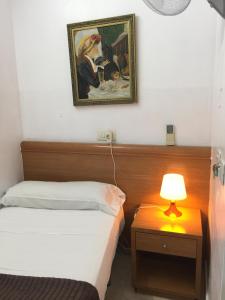 a bedroom with two beds and a picture on the wall at Hostal Mont Thabor in Barcelona