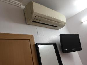 a air conditioner on the wall next to a mirror at Hostal Mont Thabor in Barcelona