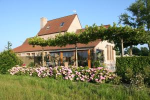 a house with a bunch of flowers in the yard at 't Leeg Huys in Lo-Reninge