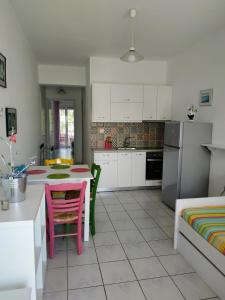 una cocina con armarios blancos y una mesa con sillas. en Livadi Apartments, en Plakias