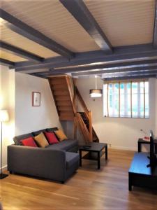 a living room with a couch and a staircase at Résidence Les Écureuils in Gréoux-les-Bains