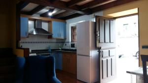 a kitchen with blue cabinets and a white refrigerator at Casa Belarmina in Cangas de Onís