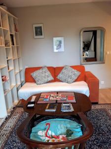 a living room with a couch and a table at Vacances Paisibles Sur La Côte Fleurie. in Trouville-sur-Mer