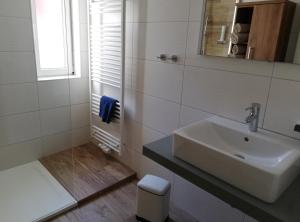 a white bathroom with a sink and a mirror at Haus Höll Herta in Hallstatt