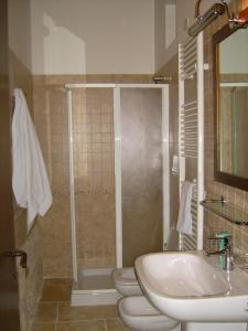 y baño con 2 aseos, lavamanos y ducha. en B&B Masseria Spilafemine, en Turi