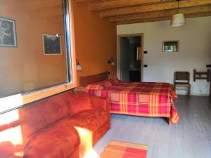 a living room with a couch and a bed at Agriturismo Val Codera in Verceia