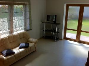 Una sala de estar con un sofá y una ventana grande. en Guest House Grāvju 11, en Jūrmala