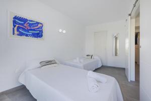 two beds in a room with white walls at Apartment Lauet in Port de Pollensa