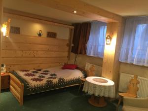 a small bedroom with a bed and a table at Pokoje Gościnne Koralik in Zakopane