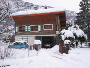 a house with a car parked in the snow at La Marmotte de la Tour in Hermillon