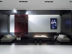 a living room with a fireplace and a large screen at The Met Hotel Thessaloniki, a Member of Design Hotels in Thessaloniki