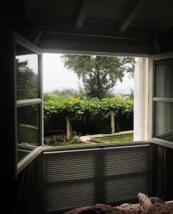 a window in a bedroom looking out at a garden at Enoturismo Novavila Rias Baixas Wine Design in Meis