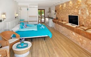 a bedroom with a blue bed and a living room at Agroturismo Fincahotel Son Pou in Felanitx