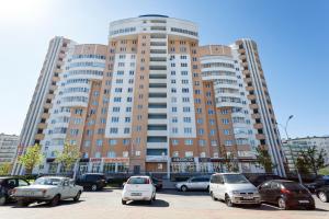 un gran edificio con coches estacionados en un estacionamiento en Minsk Apartment, en Minsk