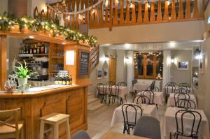 a restaurant with a bar with tables and chairs at Auberge La Cure in Oz