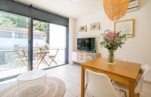 a dining room with a table and chairs and a television at Beach Apartment in the heart of Tamariu in Tamariu