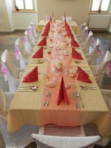 a long table with red napkins and glasses on it at Hotel Beránek in Blatná