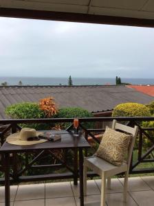 a table and chair with a hat on a balcony at Seaview on Shelly in Margate