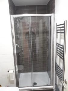 a shower with a glass door in a bathroom at Denny Guests House / Green Lane in Liverpool