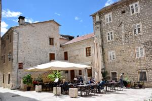 a group of people sitting at tables in front of a building at Lana & Ena Apartments in Kotor