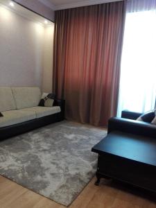 var-ketili في تبليسي: غرفة معيشة مع أريكة ونافذة