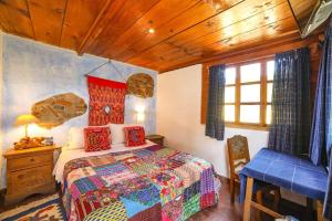 Yellow House Hostel B&B في أنتيغوا غواتيمالا: غرفة نوم بسرير وطاولة وكرسي