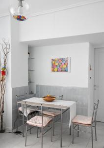 een eetkamer met een witte tafel en stoelen bij Short Stay Studio in Thessaloniki +3 foto's