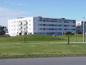 a building on a hill next to a field of grass at Mediterranium Apartments in Póvoa de Varzim