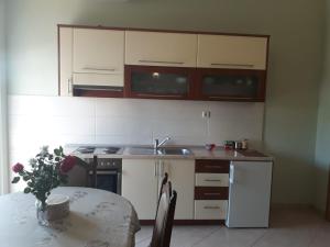 cocina con mesa, fregadero y armarios en Spirit, en Međugorje