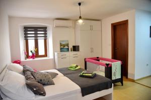 a small bedroom with a bed with a pink and black blanket at Lana & Ena Apartments in Kotor