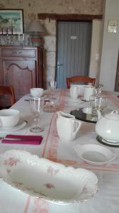 uma mesa com pratos brancos e tigelas em lembaudie em Saint-Privat-des-Prés