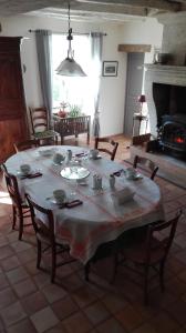a room with a table with chairs and a fireplace at lembaudie in Saint-Privat-des-Prés