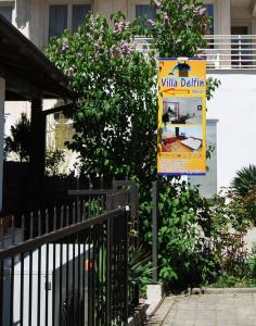 a yellow sign on a pole next to a tree at Vila Delfin in Ohrid